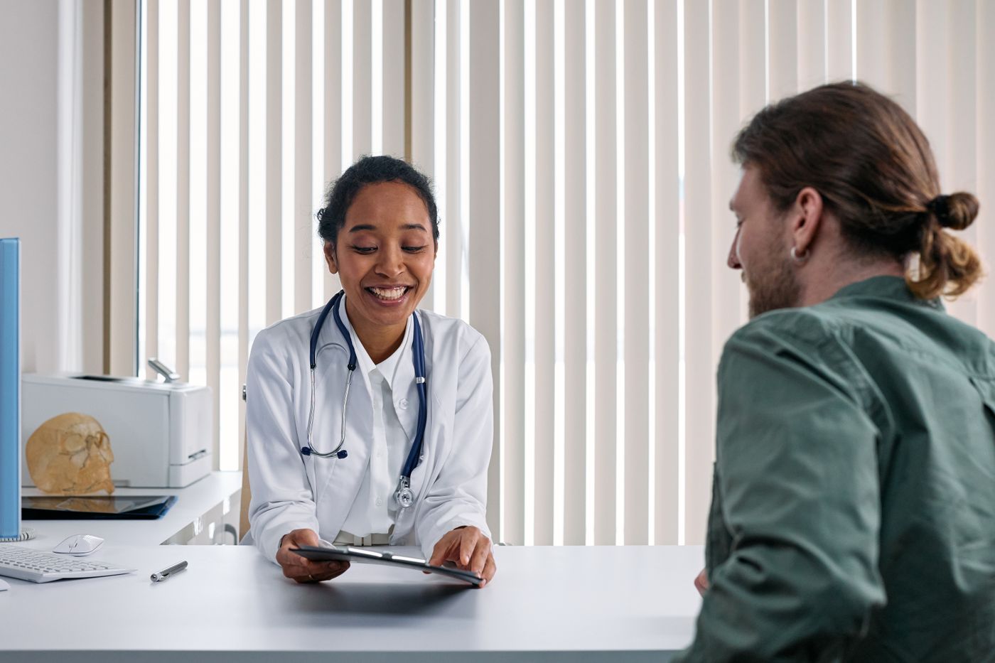 A clinician consulting with a patient in a bright, calm clinic office.
